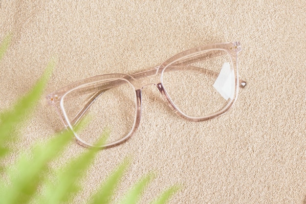 砂の上の透明なプラスチックフレームのスタイリッシュな眼鏡