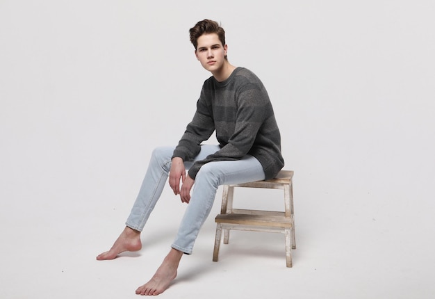 Stylish fashion man model sitting on the chair