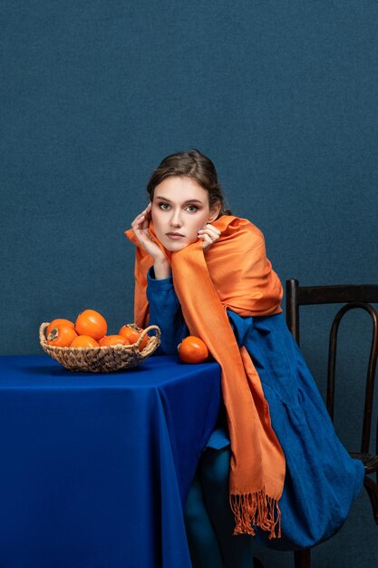 Стильная модная молодая женщина-модель с вечерним макияжем позирует в студии с экзотическим фруктом