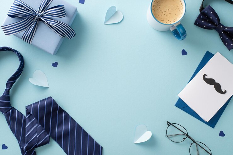 Stylish Fathers Day concept Top view shot van koffiekop, stropdas, strikje, accessoires, geschenkkist en envelop met groetekaartje op pastelblauwe achtergrond met leeg kader voor tekst