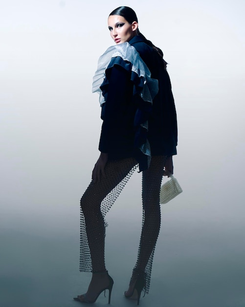 时尚的女模特在鲜<unk>的彩色灯光中摆姿势在工作室中 一个漂亮的女孩的肖像与时尚的闪闪发光的化<unk> 美丽的珠宝和配件<unk>虹色
