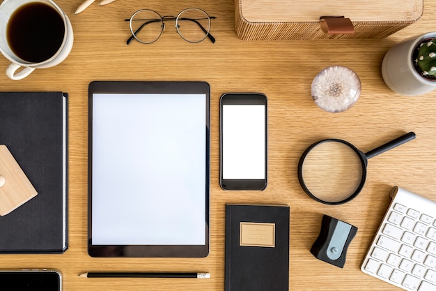 Elegante composizione aziendale piatta sulla scrivania in legno con tablet, cactus, note, macchina fotografica e forniture per ufficio nel moderno concetto di home office.