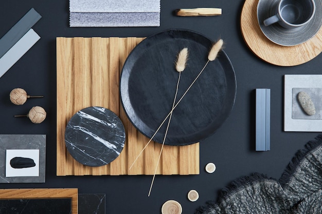 Stylish flat lay comosition of creative architect moodboard with black beige and grey samples of textile paint wooden lamella panels and marble tiles Top view Copy space TemplatexA