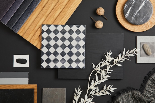 Stylish flat lay comosition of creative architect moodboard with black white beige and grey samples of textile paint wooden lamella panels and marble tiles Top view Copy space Template