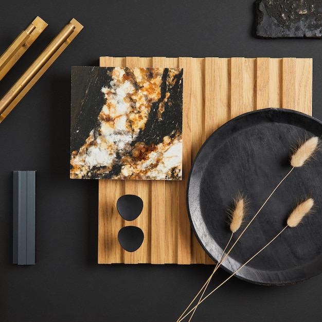 Stylish flat lay comosition of creative architect moodboard with samples of textile paint wooden lamella panel and marble tile Golden black and beige color palette Copy space Template