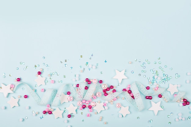 Foto bordo elegante della cornice con decorazioni carine: nastro di pizzo, stelle, paillettes e perline rosa con spazio per copiare il testo su sfondo blu. disposizione piana, vista dall'alto. concetto di bambino.