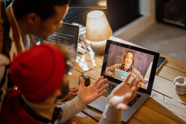 Stylish gay couple having video call with female colleague