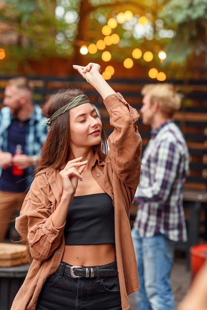 Stylish girl dancing at birthday party with her friends.