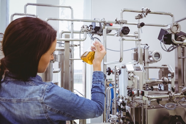 Stylish girl in denim jacket holding beaker of beer 