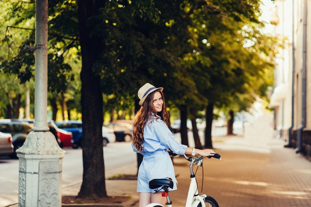 Stylish girl in a hat with a bicycle