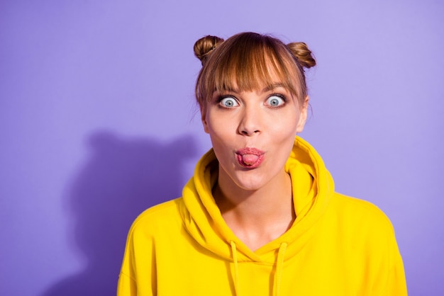 Stylish girl posing against the purple wall