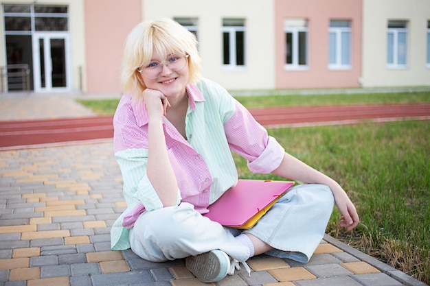 Stylish girl student sitting at the stadium near the school or college