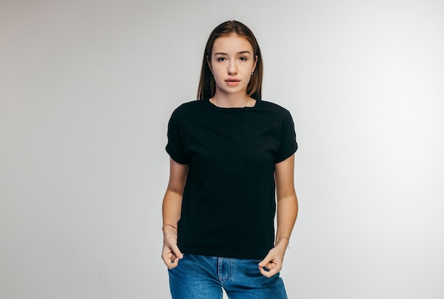 Stylish girl wearing black t-shirt posing in studio