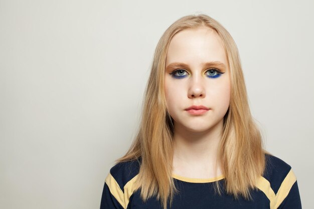 Stylish girl with blue eye shadow makeup on white background