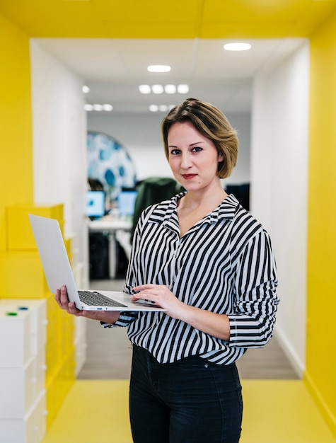 Photo stylish girl with laptop in office