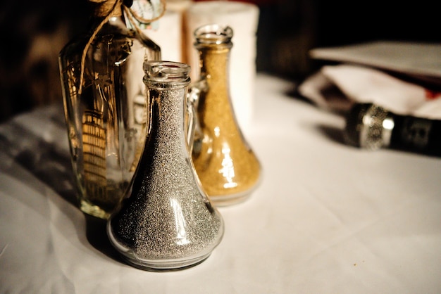 イブニングレセプションでの結婚式の伝統儀式のための砂を入れたスタイリッシュなガラスの瓶