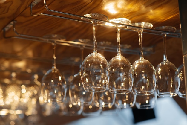 stylish glasses for various alcoholic beverages hang over the bar in a modern restaurant glasses for wine champagne