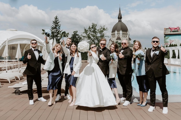 Foto sposo e sposa alla moda con i loro amici