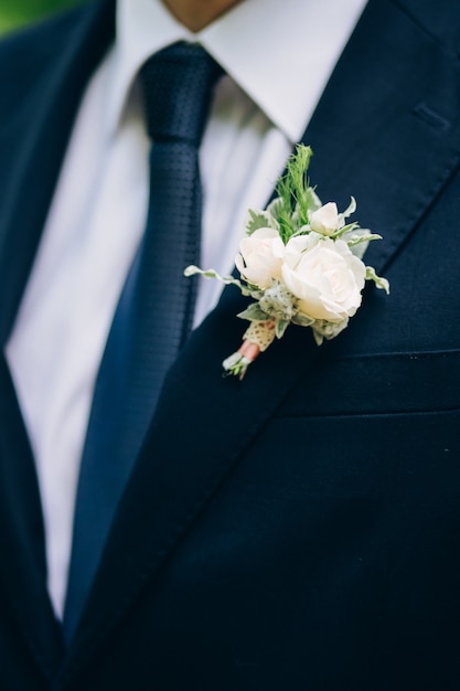 Testimoni dello sposo alla moda che aiutano sposo felice che si prepara al mattino per la cerimonia di nozze. uomo di lusso in tuta in camera. giorno del matrimonio.