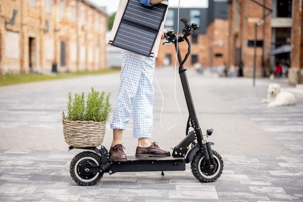 Stylish guy drives electric scooter and uses phone on the move