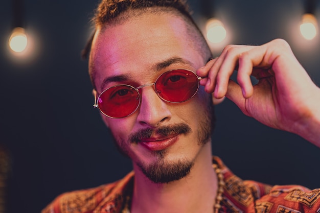 Stylish guy with dreadlocks wearing pink sunglasses