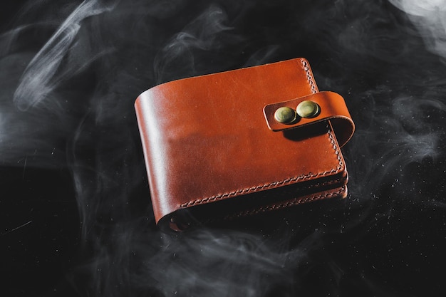 Stylish handmade brown leather wallet on a gray background Product made of genuine leather