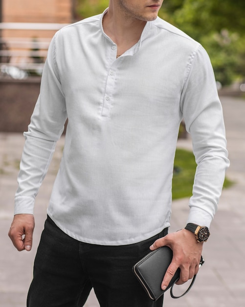 Photo stylish handsome model man in casual clothes in the street with watch and leather clutch