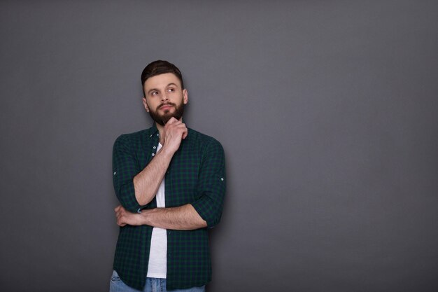 Stylish handsome trendy fashion bearded man in denim wear is posing 