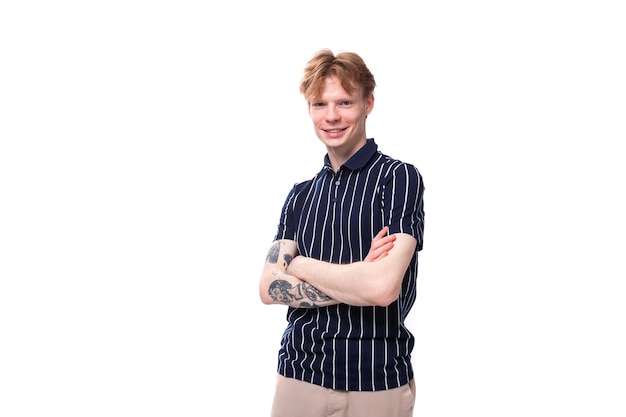 Stylish handsome young blond man with tattoos on his arm on a white background