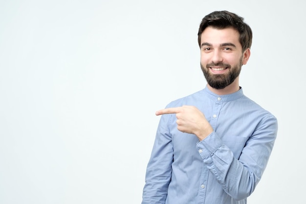 脇を指しているスタイリッシュなハンサムな若いヒスパニック系男性