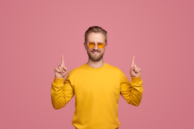 Stylish hipster pointing up in studio