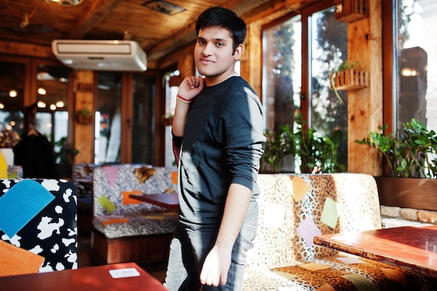 Stylish indian man in casual wear posing indoor cafe