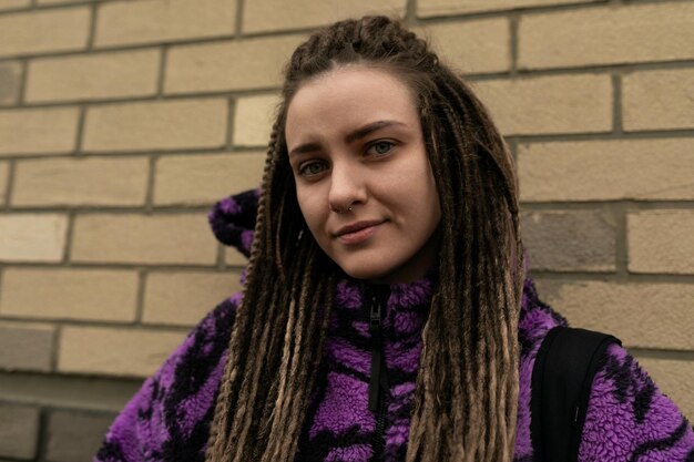 Stylish informal woman with dreadlocks wearing a purple jacket lifestyle concept