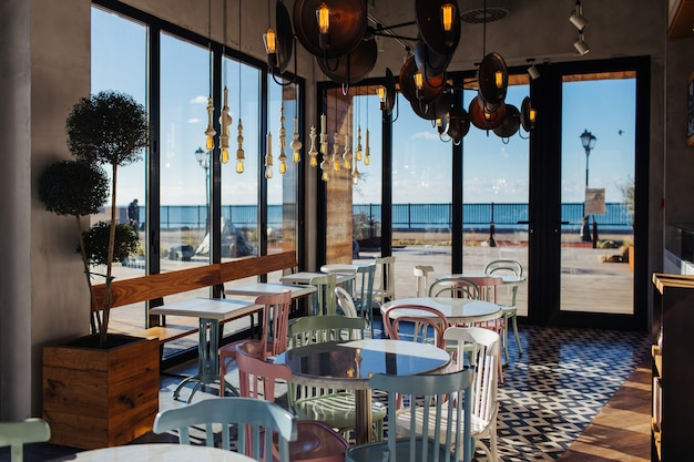 Elegante caffè interno in stile vintage, con ampie finestre e vista sul mare