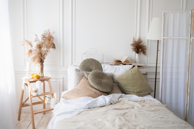 Interni eleganti della camera da letto confortevole. interno scandinavo della camera da letto. accogliente appartamento in tenui colori beige e bianco.