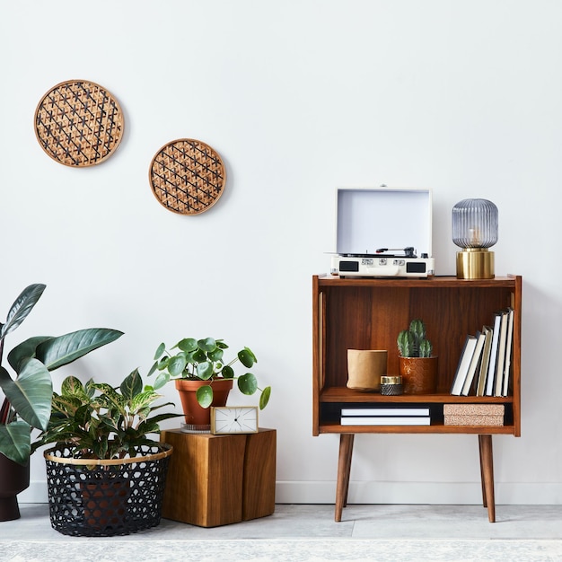 Stylish interior of living room with design wooden shelf velvet\
sofa a lot of plants mock up poster map vinyl recorder book and\
personal accessories in vintage home decor template