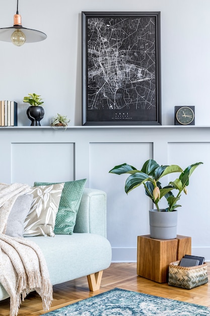 Stylish interior of living room with mock up poster frame,
design sofa, wooden cube, pendant lamp, plant, carpet, pillows,
plaid, books, clock and elegant personal accessories in modern home
decor.