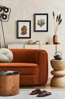 Interni eleganti di un soggiorno moderno con due cornici per poster, divano dal design retrò, tavolino da caffè e accessori personali creativi. spazio hipster. modello.