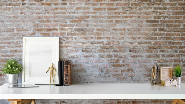 Photo stylish interior with mock up blank poster frame, plant, vintage books and copy space