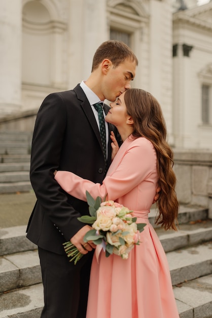 Stylish Just merried. wedding couple.Close up. Happy bride and groom walking near old castle. Bridal wedding bouquet of flower