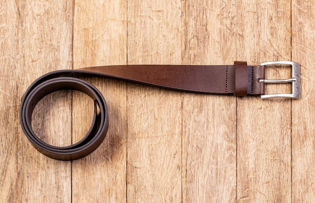 Stylish leather belt on wooden background