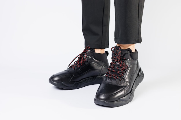 Стильные кожаные черные короткие мужские осенние кроссовки на белом фоне на мужских ногах Кроссовки зимняя коллекция 2022