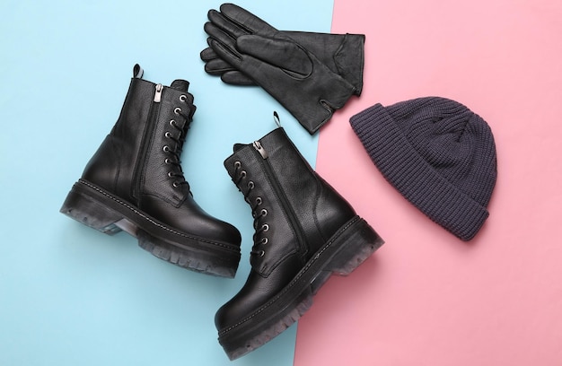 Stylish leather boots beanie hat and gloves on blue pink pastel background