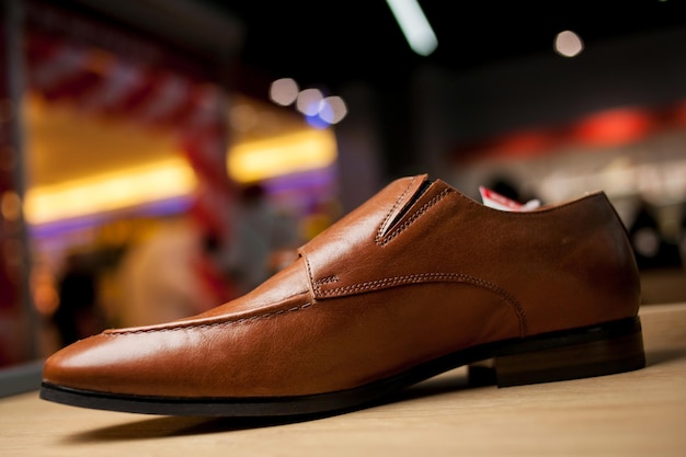 매장의 선반에 있는 세련된 가죽 남성용 신발 스탠드에 있는 갈색 남성용 신발