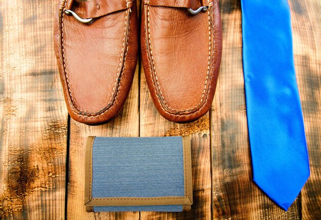 Stylish leather shoes on wooden background. Groom ready for wedding. Menswear and accessories. Matching wallet and necktie. Fashion and style. Male outfit fashion accessories. Accessories shop.