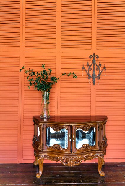 Stylish living room interior design with retro wooden chest of drawers Orange or terracotta walls Home decor