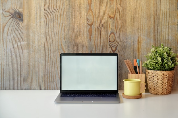 Stylish loft workspace with white screen laptop. 