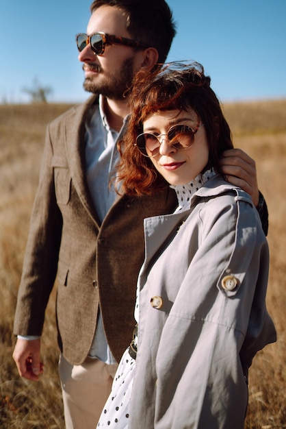 Stylish and loving couple enjoying each other outdoors Stylish couple walking and hugging