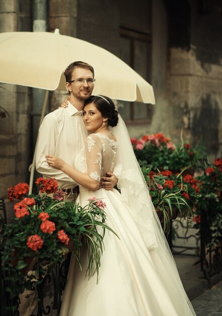 Stylish luxury bride and elegant groom, hugging with tenderness,on the background of the old city Lviv