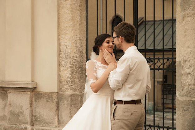 Stylish luxury bride and elegant groom hugging with tendernesson the background of the old city Lviv